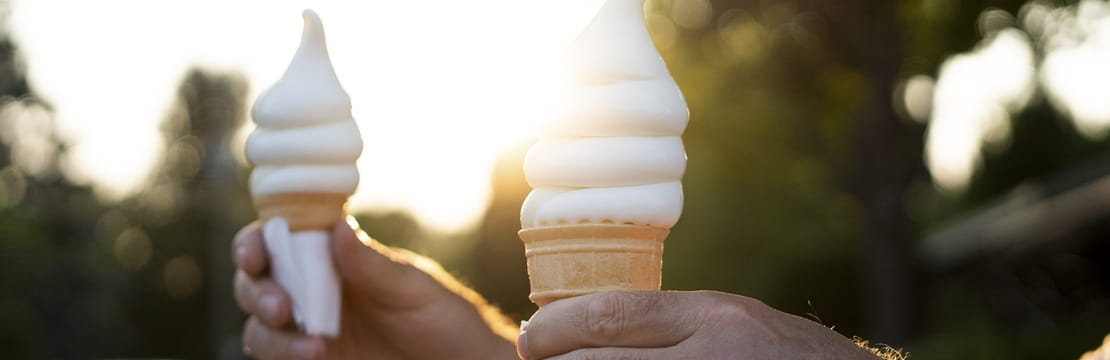 Two retirees holding ice cream cones outdoors at sunset, reflecting how enjoying simple moments and meaningful experiences can contribute to a fulfilling retirement beyond financial security.